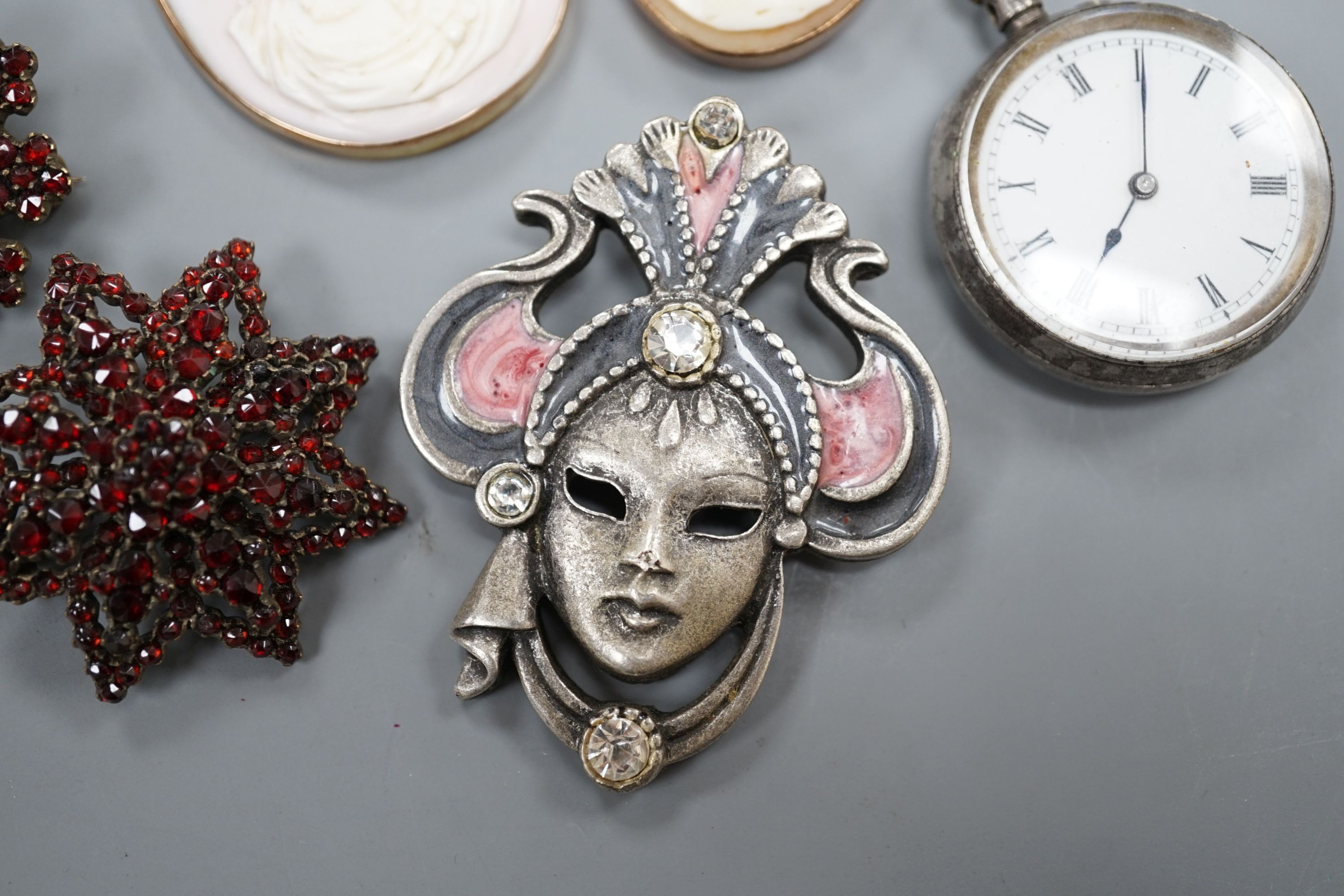 A yellow metal mounted cameo shell brooch and a similar pendant, two brooches, a white metal fob watch and one other brooch.